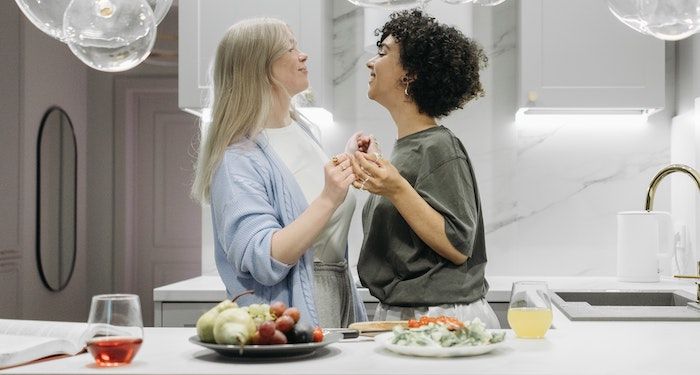 two women dancing and smiling in kitchen.jpg.optimal