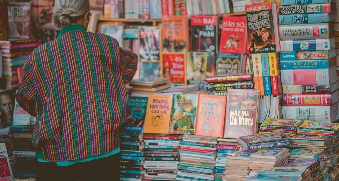 a person with gray hair looks at books.jpg.optimal