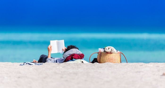 person reading on the beach.jpg.optimal